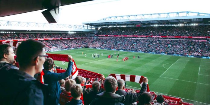 Aficionados de fútbol sujetando banderas en el estado del Liverpool, Inglaterra