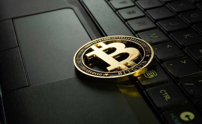 Ordenador y simbolo de bitcoin.