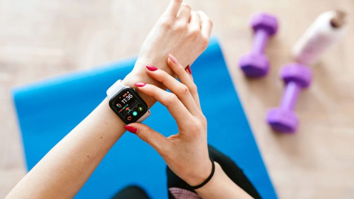 Mujer manipulando un smartwatch en el gimnasio