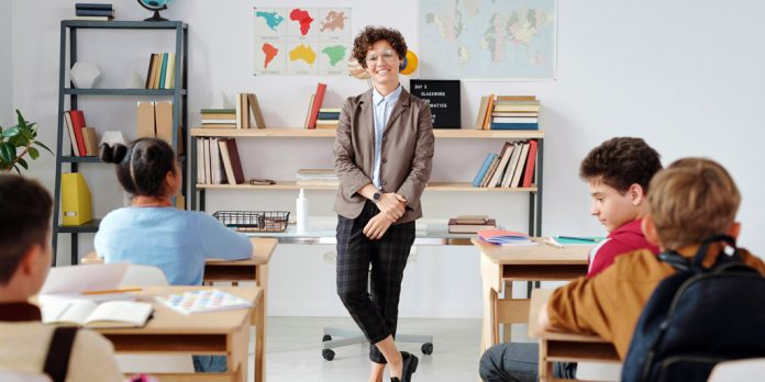 Profesora en un aula llena de niños estudiando