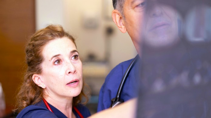 Dos sanitarios profesionales médicos mirando una radigrafía